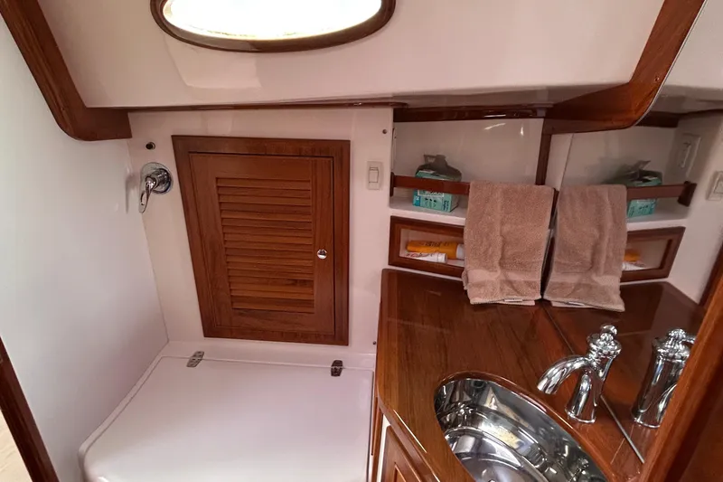 2015 Alerion Coastal Cruiser bathroom with wooden cabinetry and stainless steel sink.