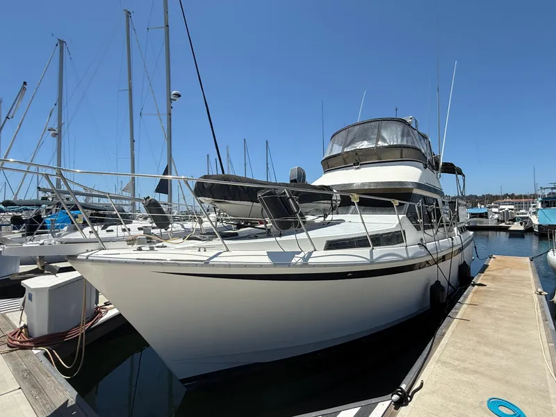 1986 Kha Shing Nautique yacht docked at marina under clear blue sky.