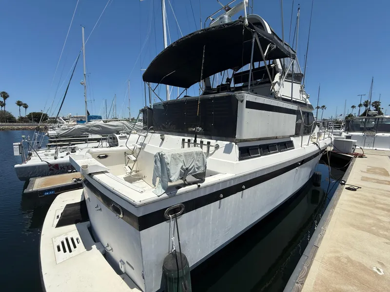 1986 Kha Shing Nautique yacht docked at marina under clear blue sky.