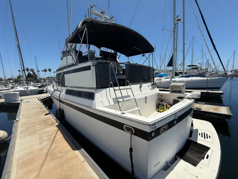 1986 Kha Shing Nautique yacht docked at marina under clear blue sky.