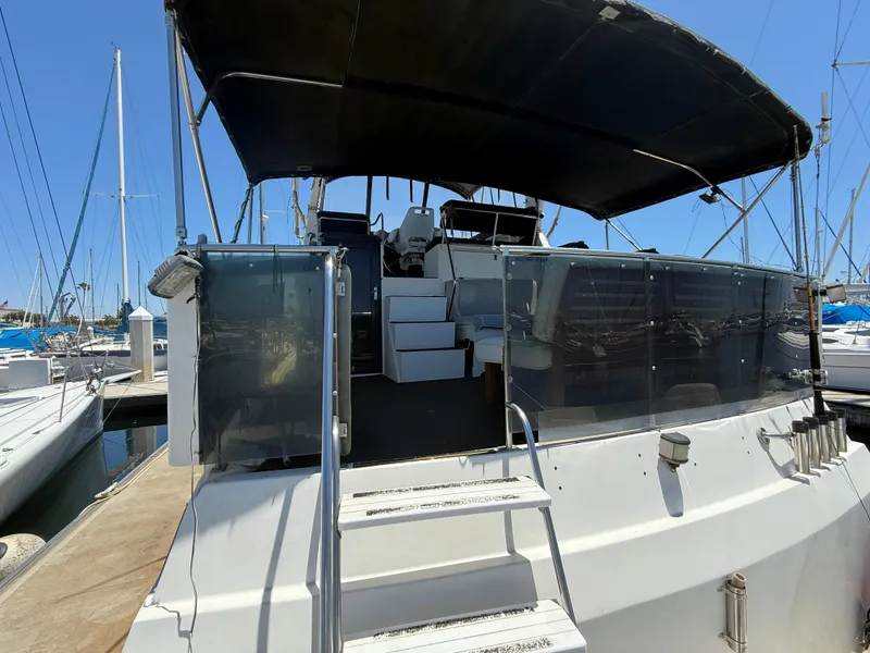 1986 Kha Shing Nautique yacht with covered deck, docked at marina.