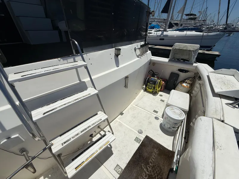 1986 Kha Shing Nautique boat deck with ladder and equipment, docked at marina.