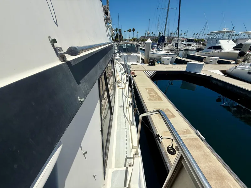 1986 Kha Shing Nautique yacht docked at a marina under clear blue skies.