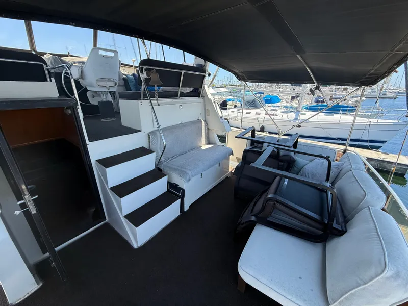 1986 Kha Shing Nautique yacht interior with seating and helm, docked at marina.