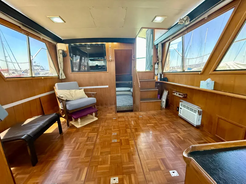 Interior of 1986 Kha Shing Nautique yacht with wood paneling and seating.