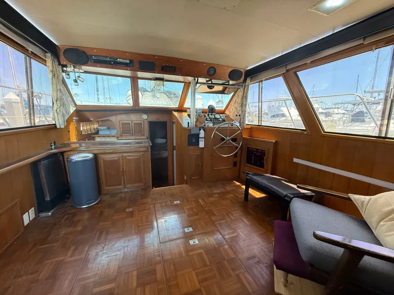 Interior of 1986 Kha Shing Nautique yacht with wooden decor and helm station.