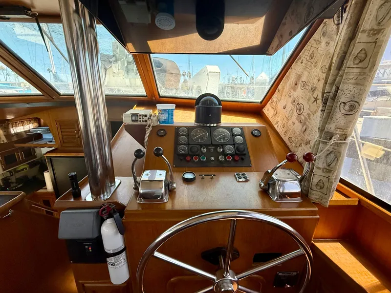 1986 Kha Shing Nautique helm with steering wheel, control panel, and nautical instruments.