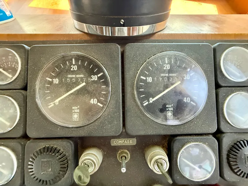 1986 Kha Shing Nautique dashboard with engine hour meters and compass.