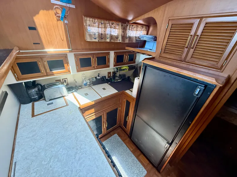 1986 Kha Shing Nautique yacht kitchen with wooden cabinets and modern appliances.