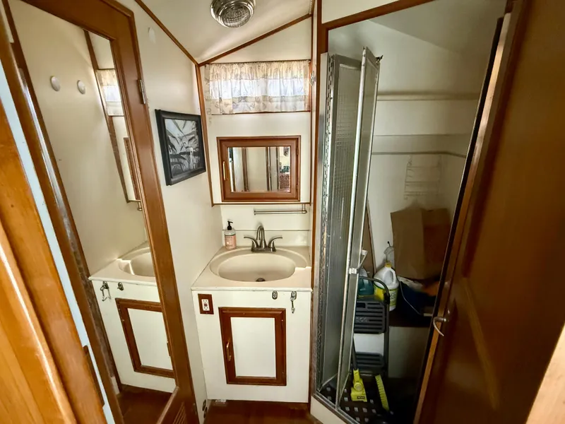 1986 Kha Shing Nautique bathroom with sink, mirror, and shower.