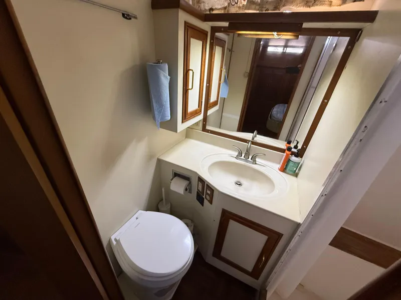 1986 Kha Shing Nautique yacht bathroom with sink, mirror, and toilet.
