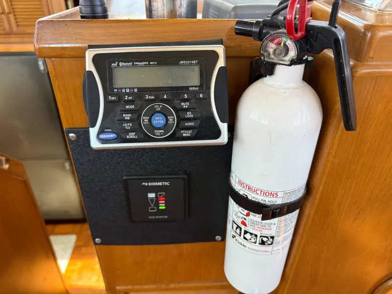 Boat interior with radio, fire extinguisher, and control panel on Kha Shing Nautique 1986.