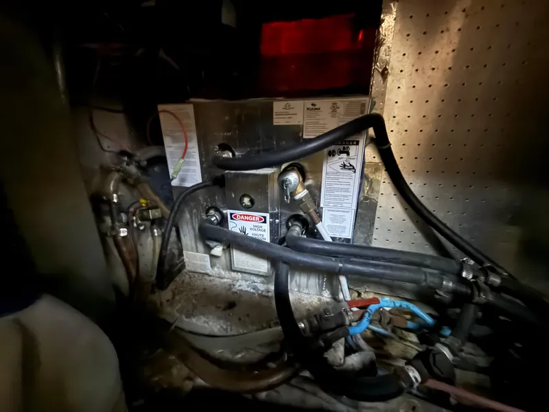 Engine compartment of a 1986 Kha Shing Nautique boat, featuring wiring and warning labels.