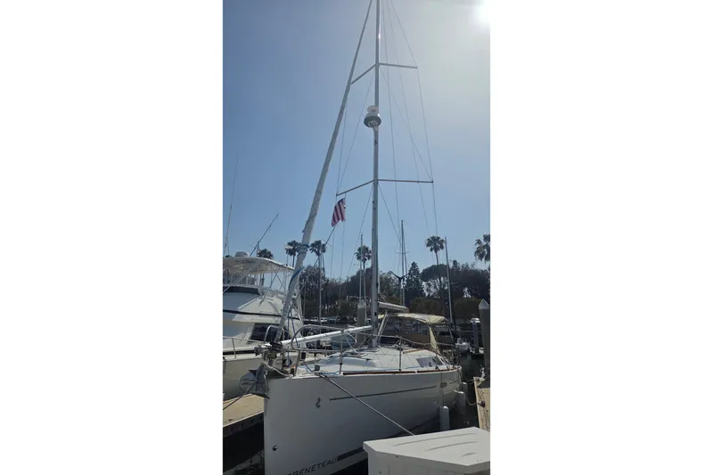 2010 Beneteau Oceanis 37 sailboat docked under clear sky with palm trees.