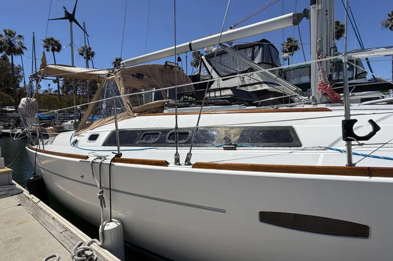 2010 Beneteau Oceanis 37 sailboat docked at marina, sunny day, palm trees in background.