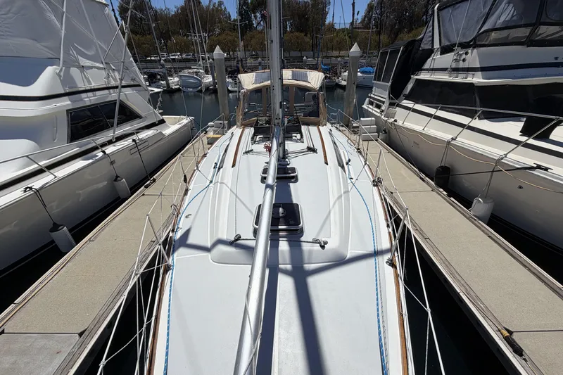 2010 Beneteau Oceanis 37 sailboat docked between yachts in a marina.