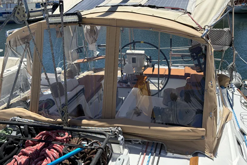 Cockpit of a 2010 Beneteau Oceanis 37 sailboat with protective canopy and steering wheel.