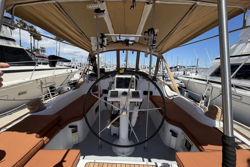Cockpit view of a 2010 Beneteau Oceanis 37 sailboat docked at a marina.