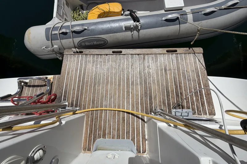 Teak deck of 2010 Beneteau Oceanis 37 with inflatable dinghy alongside.