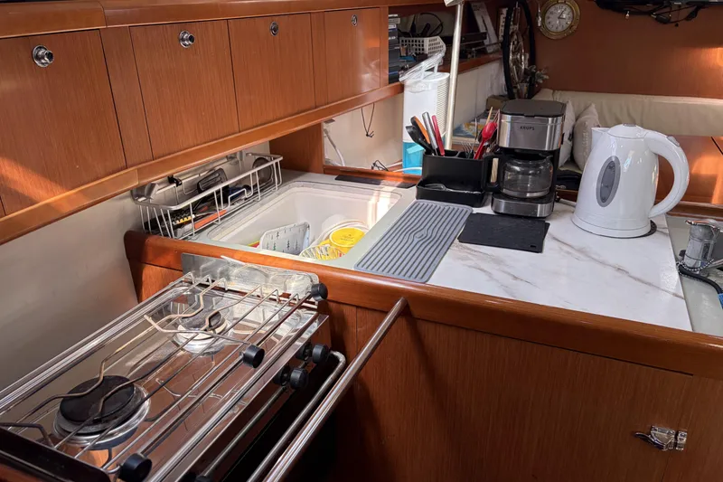 Galley kitchen in 2010 Beneteau Oceanis 37 yacht with stove, sink, and appliances.