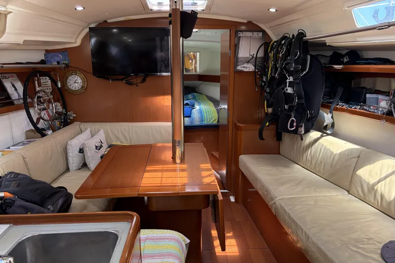 Interior of a 2010 Beneteau Oceanis 37 sailboat with cozy seating and nautical decor.