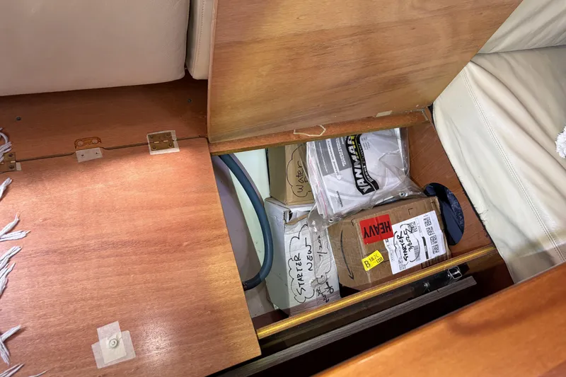 Storage compartment in a 2010 Beneteau Oceanis 37 yacht with labeled boxes and packages.