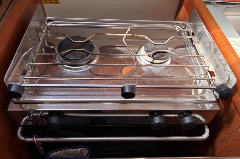 Stove in 2010 Beneteau Oceanis 37 yacht kitchen, featuring two burners and metal grates.