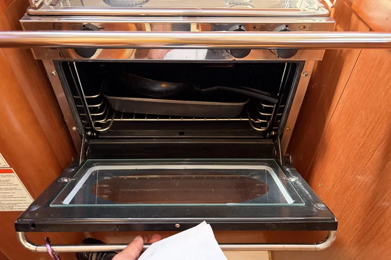 Open oven inside a 2010 Beneteau Oceanis 37 yacht kitchen.