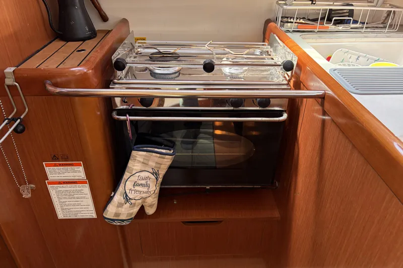 Galley kitchen in 2010 Beneteau Oceanis 37 sailboat with oven and mitt.