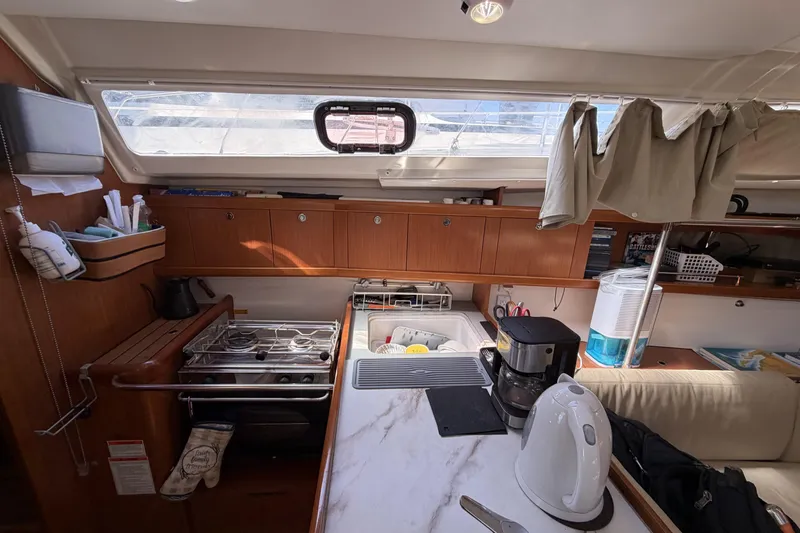 Interior of 2010 Beneteau Oceanis 37 yacht kitchen with stove, sink, and appliances.