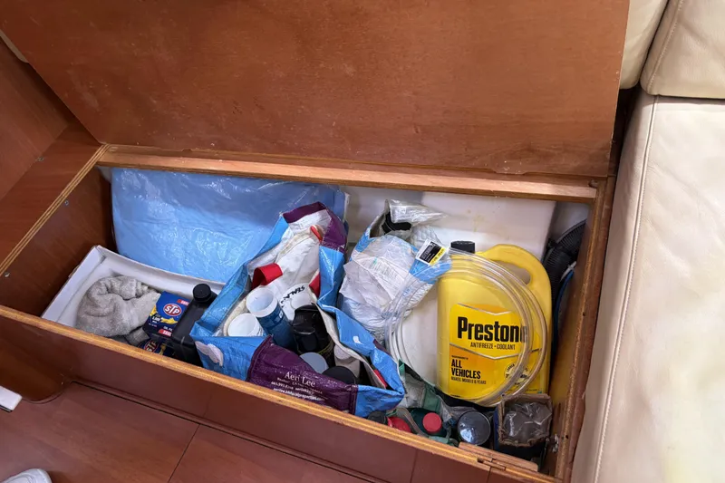 Storage compartment on a 2010 Beneteau Oceanis 37 with maintenance supplies and coolant.