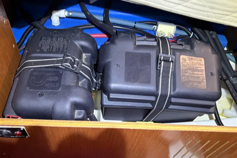 Battery compartment of a 2010 Beneteau Oceanis 37 sailboat, featuring secured battery boxes.