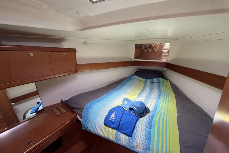 Cozy cabin interior of 2010 Beneteau Oceanis 37 sailboat with bed and storage.