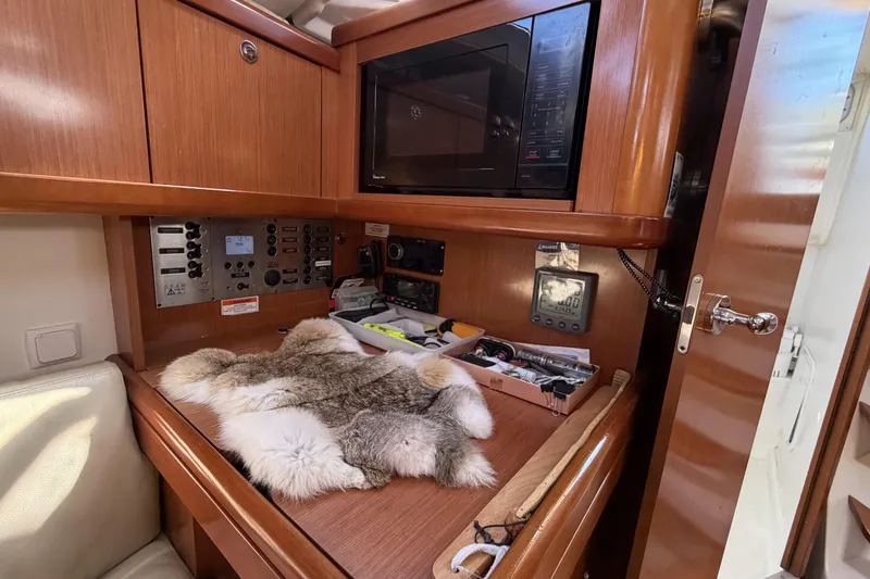 Interior of 2010 Beneteau Oceanis 37 yacht with navigation equipment and wooden cabinetry.