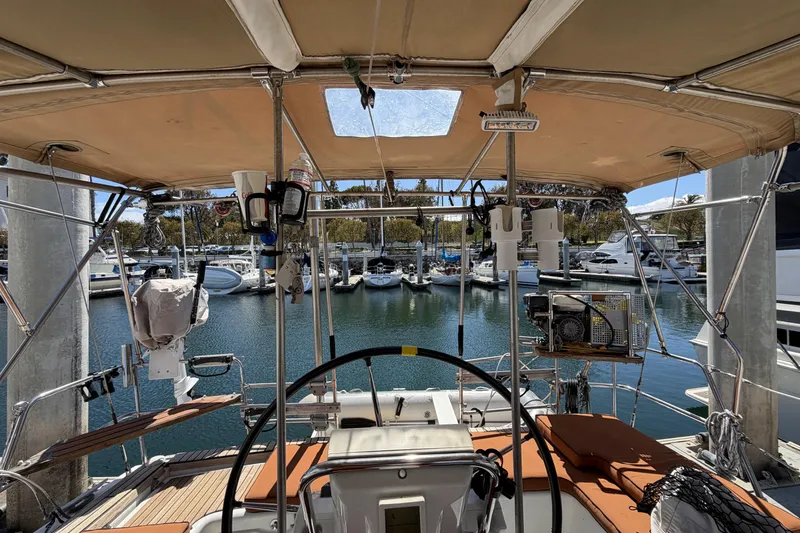 Cockpit view of a 2010 Beneteau Oceanis 37 sailboat docked at a marina.