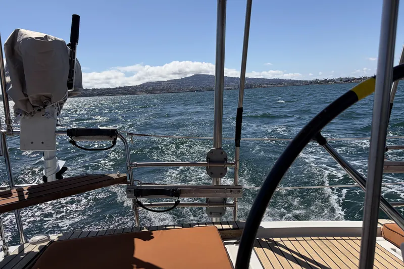 Beneteau Oceanis 37 sailing on open water, 2010 model, scenic coastal view.