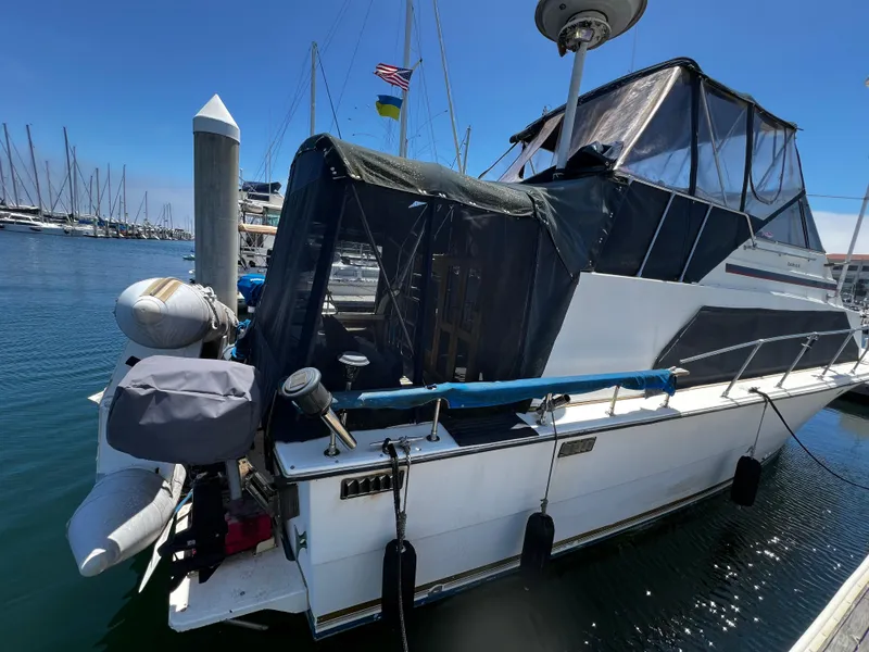 1982 Carver Mariner 33 docked at marina, featuring covered deck and nautical equipment.