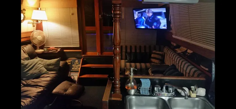 Interior of a 1982 Carver Mariner 33 yacht with cozy seating and a TV.