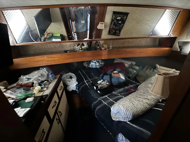 1982 Carver Mariner 33 cabin interior with bed, storage, and personal items.