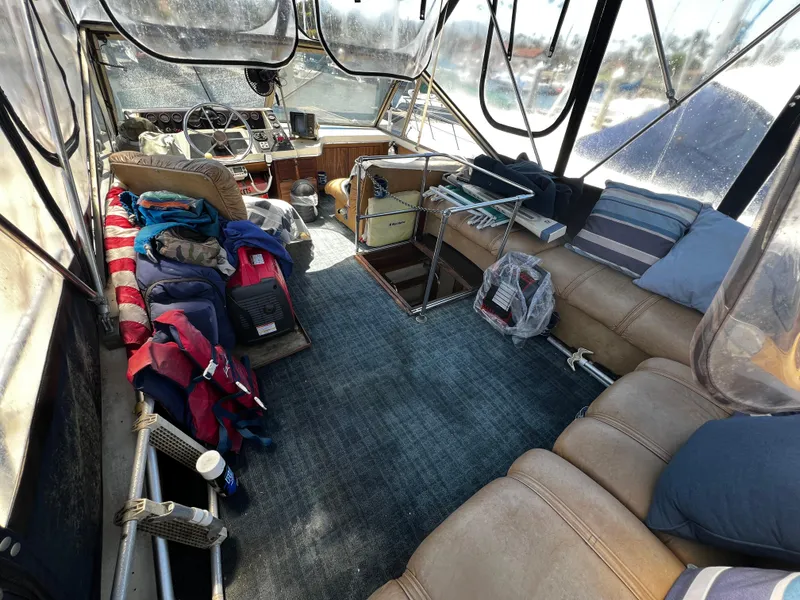 1982 Carver Mariner 33 interior with seating, helm, and nautical gear.