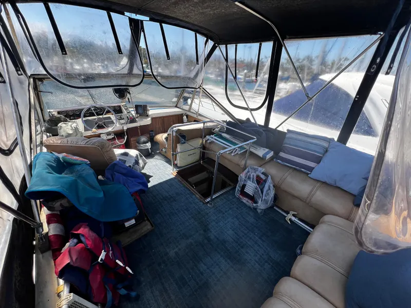 1982 Carver Mariner 33 interior with seating, helm, and nautical accessories.