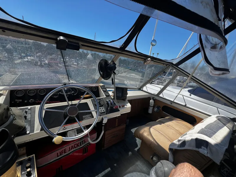 Interior of 1982 Carver Mariner 33 boat with steering wheel and navigation equipment.