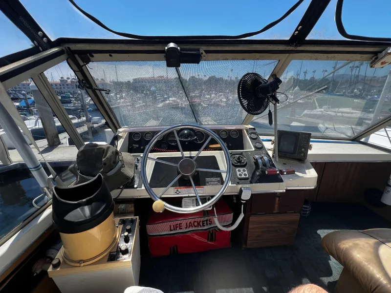 1982 Carver Mariner 33 helm with steering wheel, navigation instruments, and life jackets.