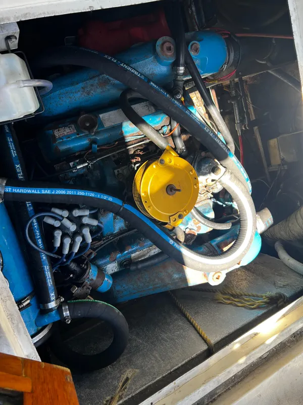 Engine compartment of a 1982 Carver Mariner 33 boat, showcasing blue and yellow components.
