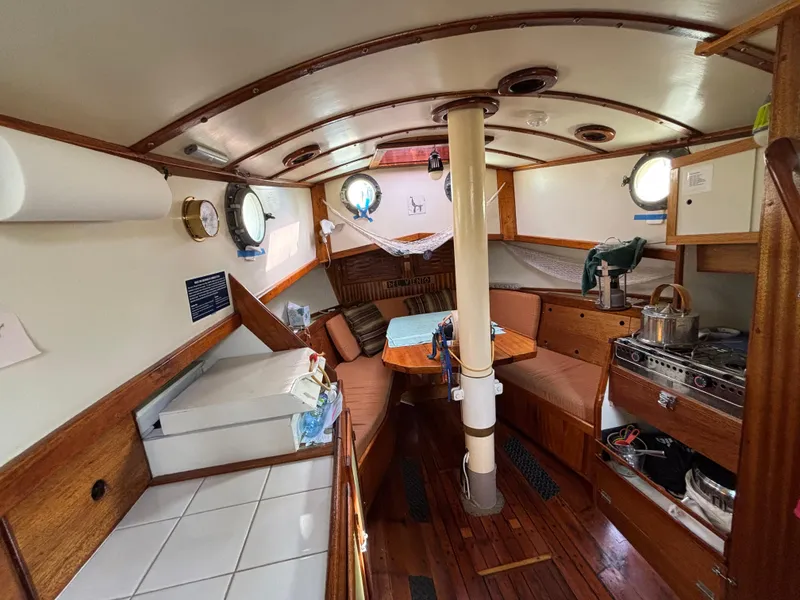 Interior of 1975 Custom 45’ Thomas Colvin “Tamarack” Schooner, featuring cozy seating and kitchen area.