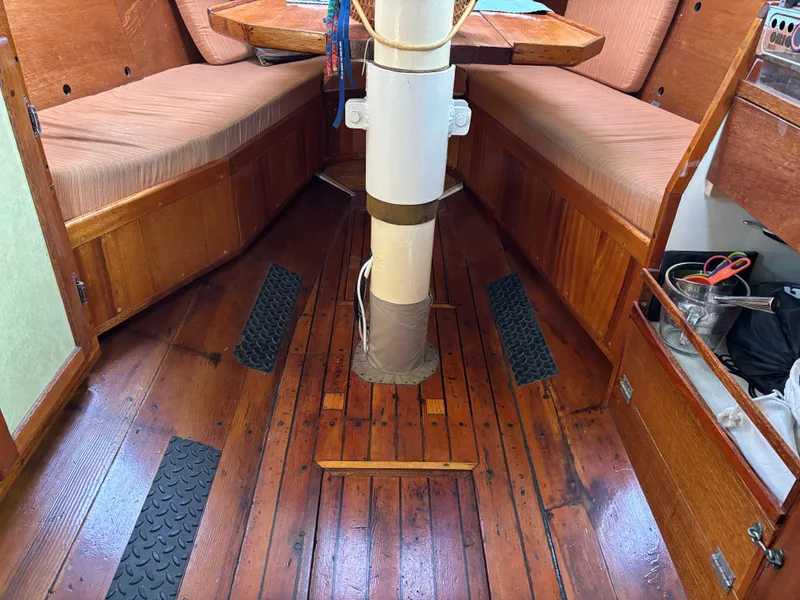Interior of 1975 Custom 45’ Thomas Colvin “Tamarack” Schooner with wooden flooring and seating.