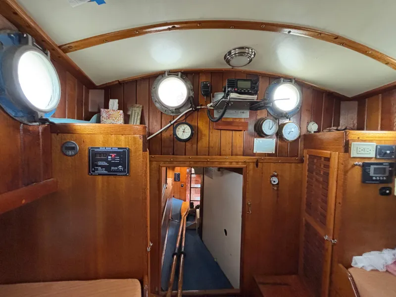 Interior of 1975 Custom 45’ Thomas Colvin “Tamarack” Schooner with wooden paneling and nautical instruments.