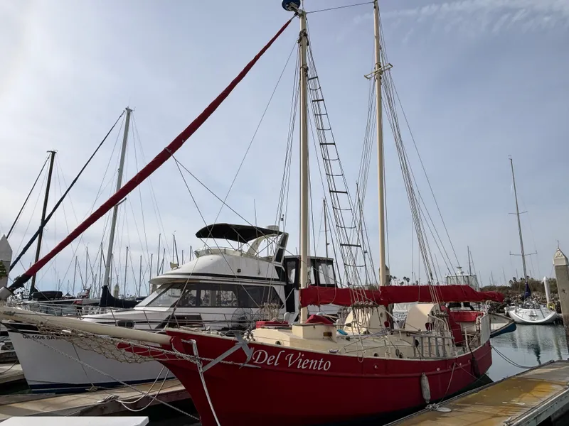 Red 1975 Custom 45’ Thomas Colvin “Tamarack” Schooner docked at marina.