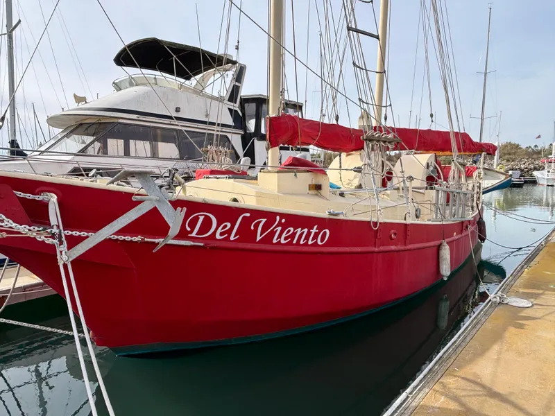 Red 1975 Custom 45’ Thomas Colvin “Tamarack” Schooner named "Del Viento" docked at marina.