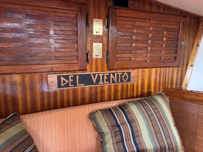 Interior of 1975 Custom 45’ Thomas Colvin “Tamarack” Schooner with wooden paneling and cushions.